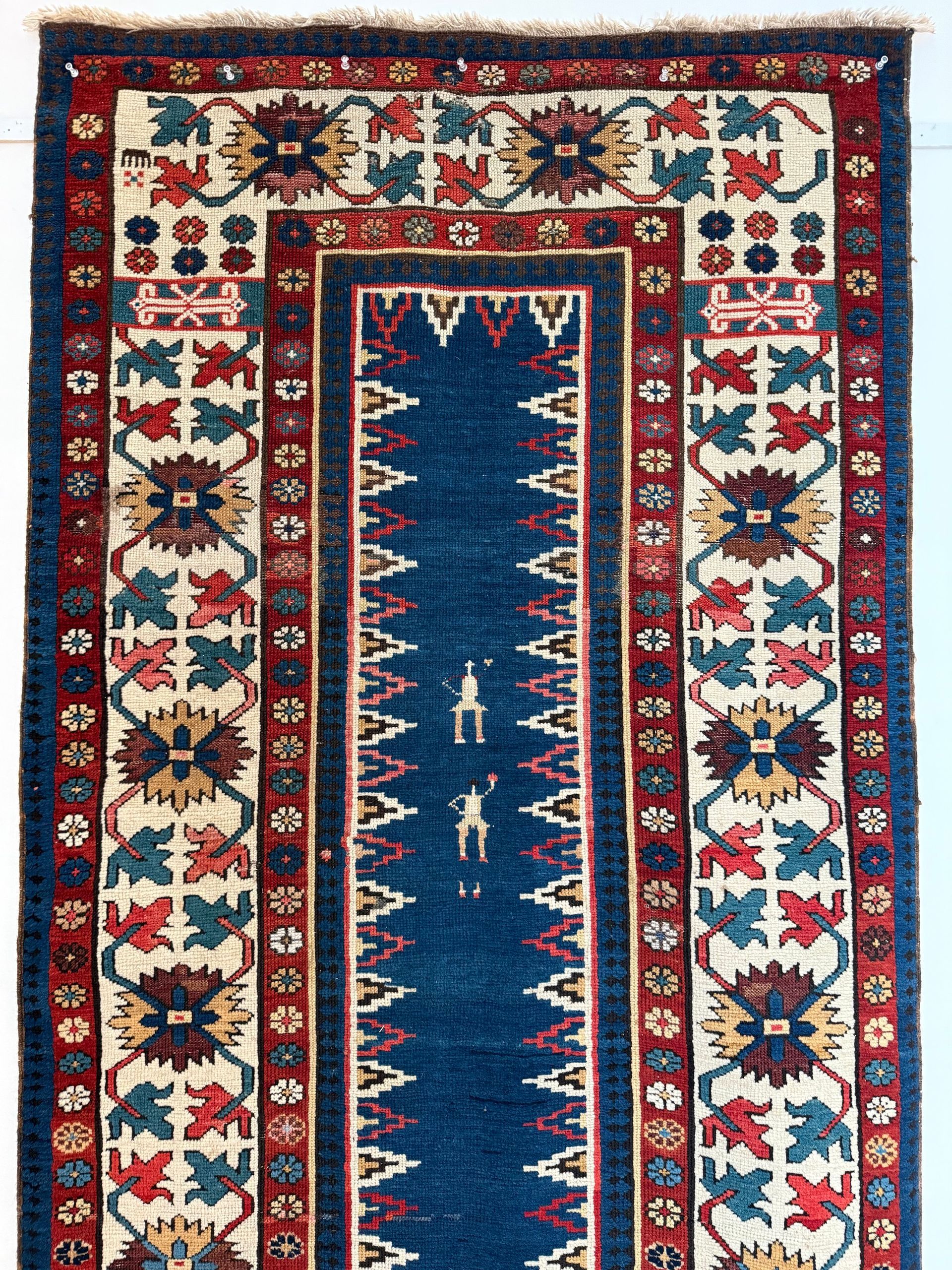 A rug with a blue border and a ruler on it