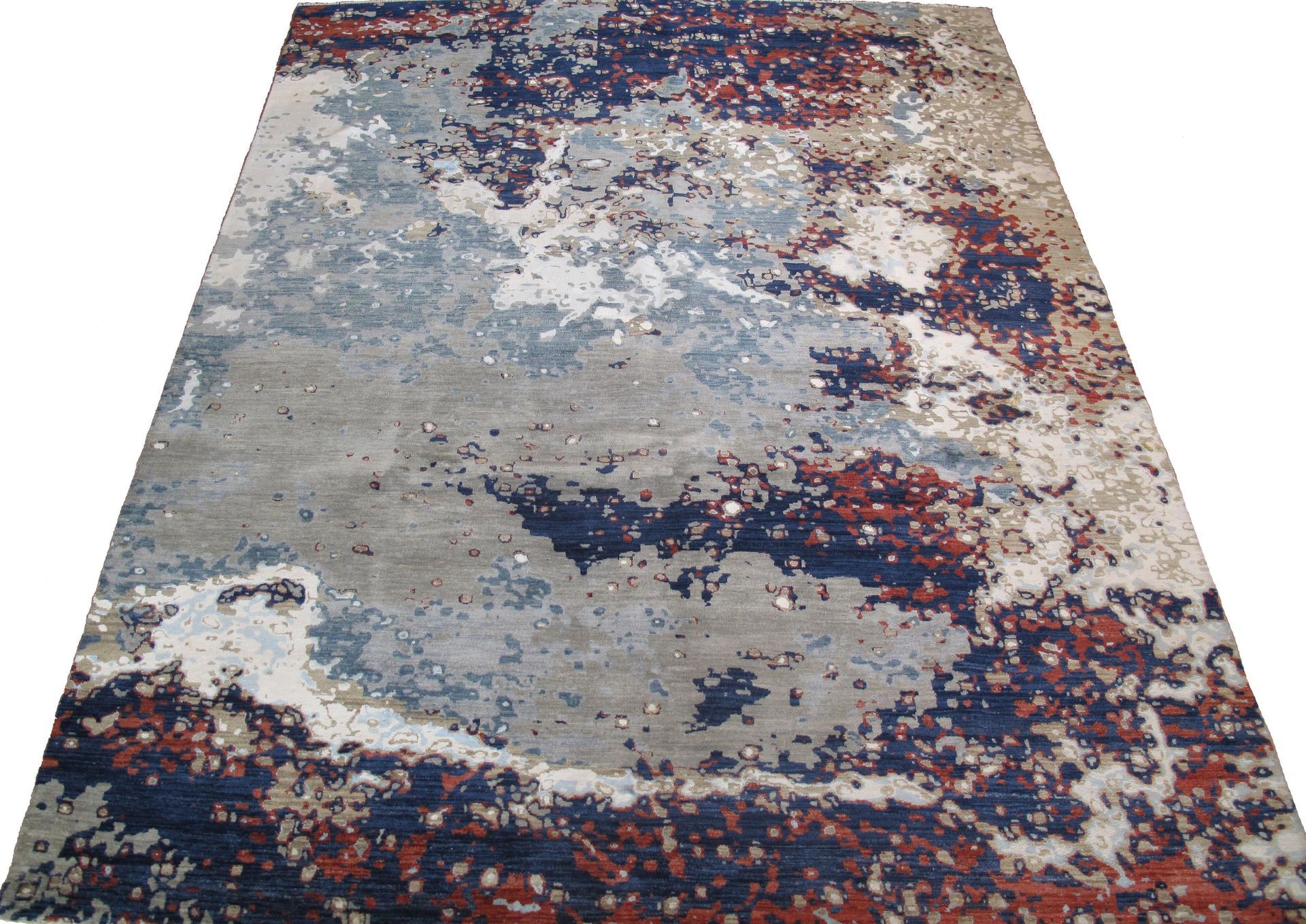 A rug with a colorful pattern on it is sitting on a white surface.
