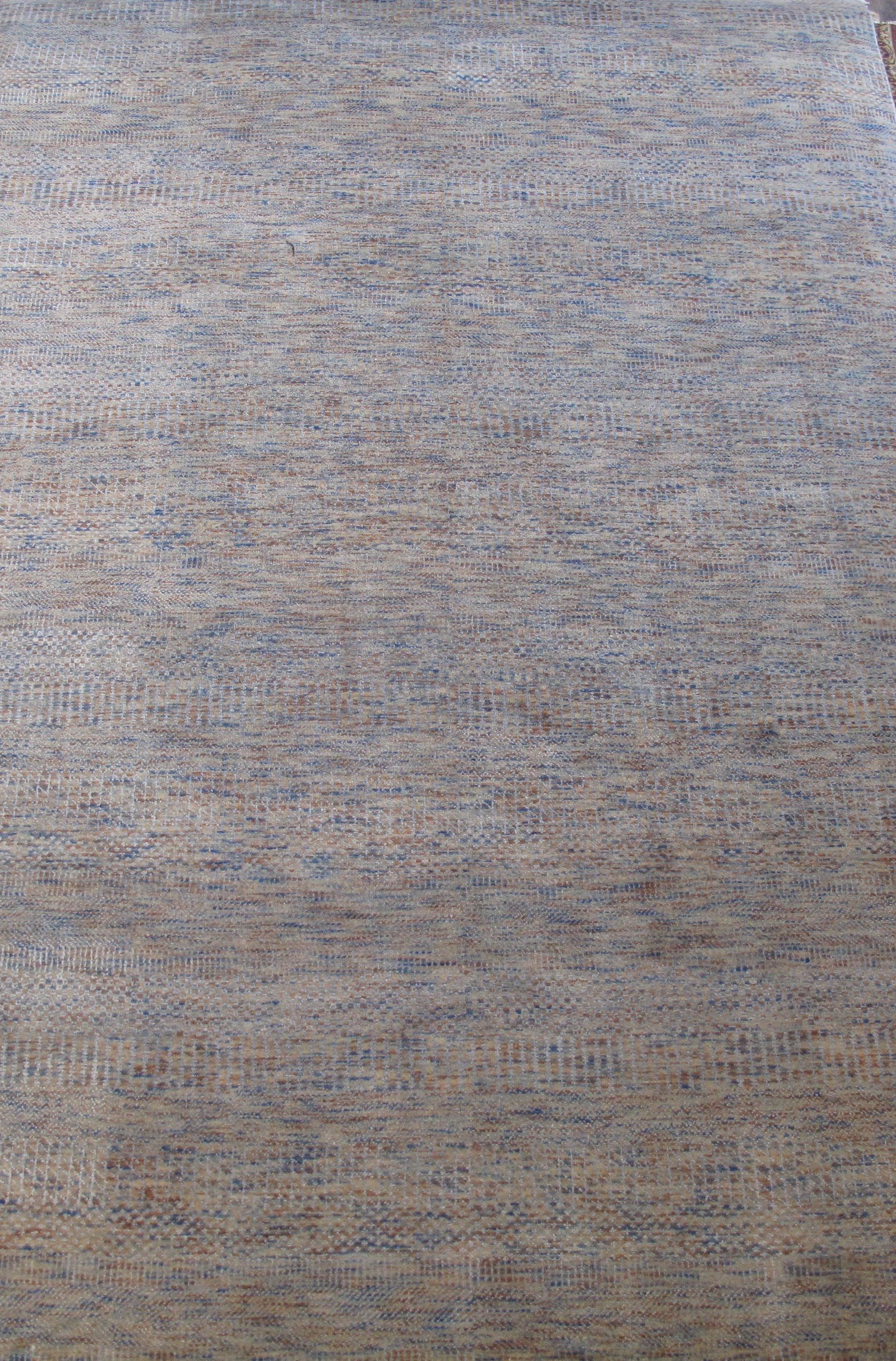 A close up of a rug on a brick floor.