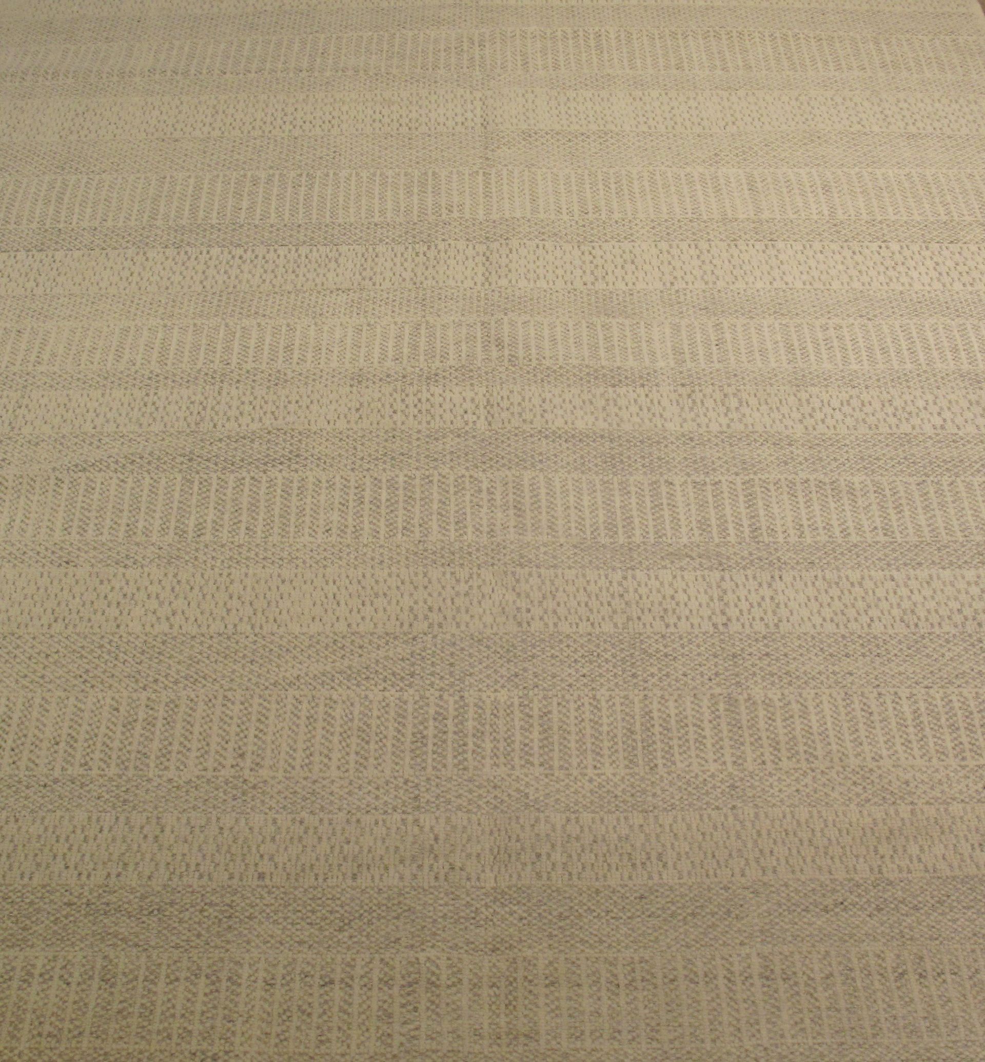 A close up of a beige rug with a pattern on it.