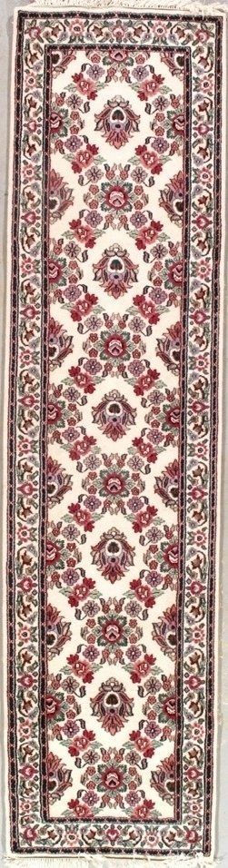 A long rug with a floral pattern on it is hanging on a wall.