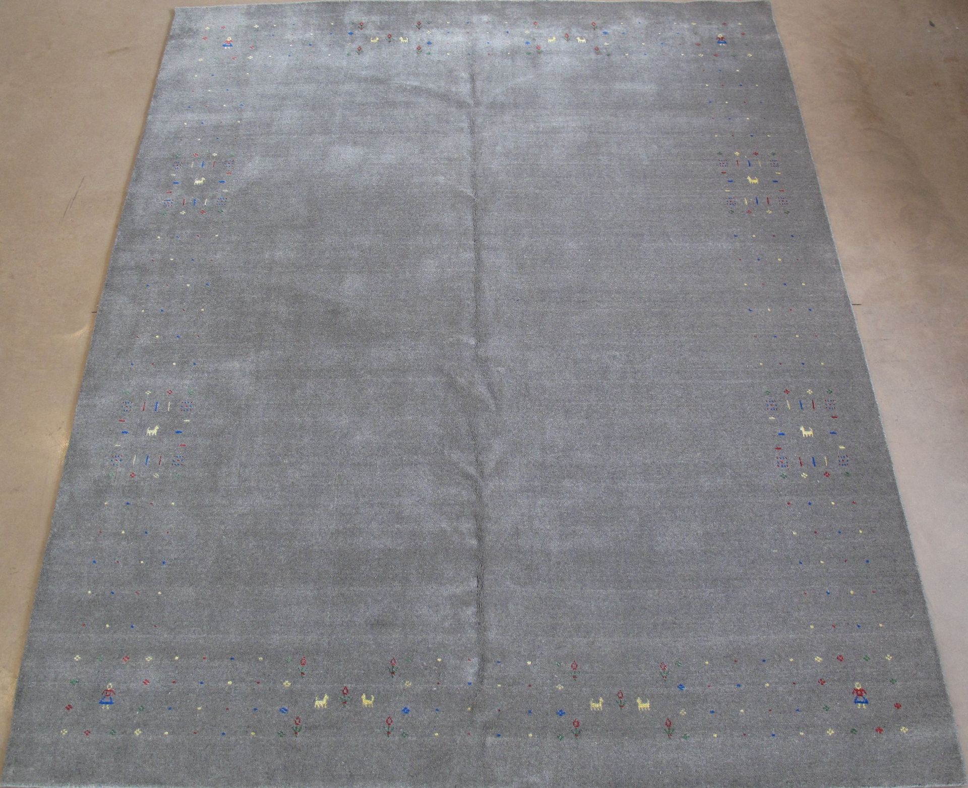 A gray rug is laying on a wooden floor