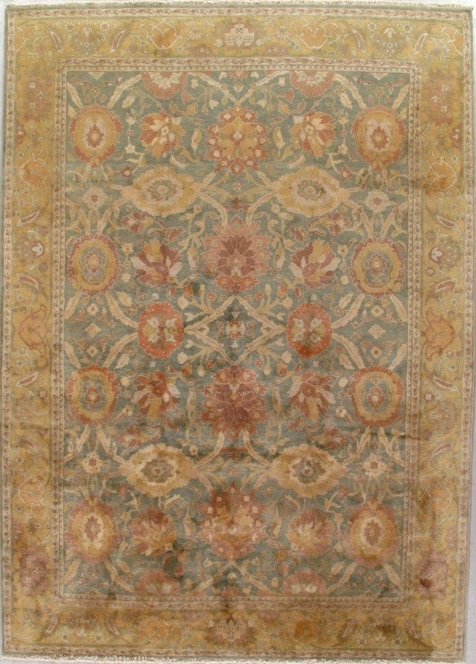 A rug with a floral pattern on it is hanging on a wall.