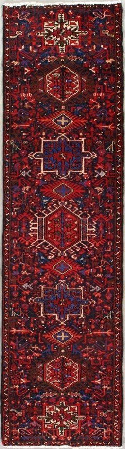 A red and blue rug with a pattern on it is on a white surface.