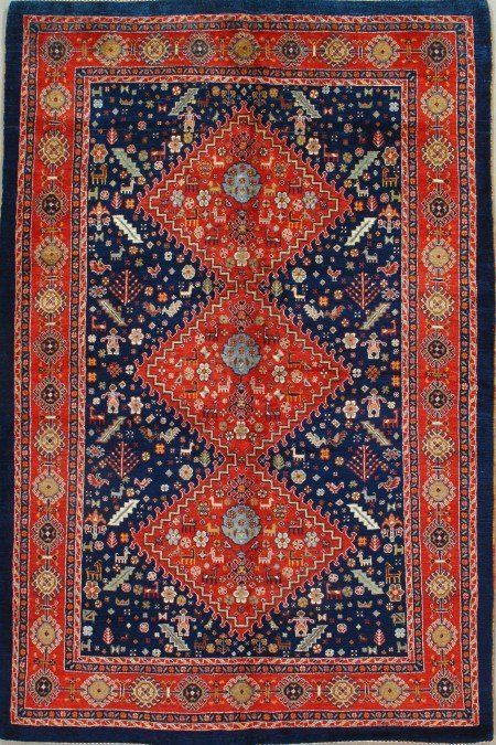A red and blue rug with a diamond pattern on it