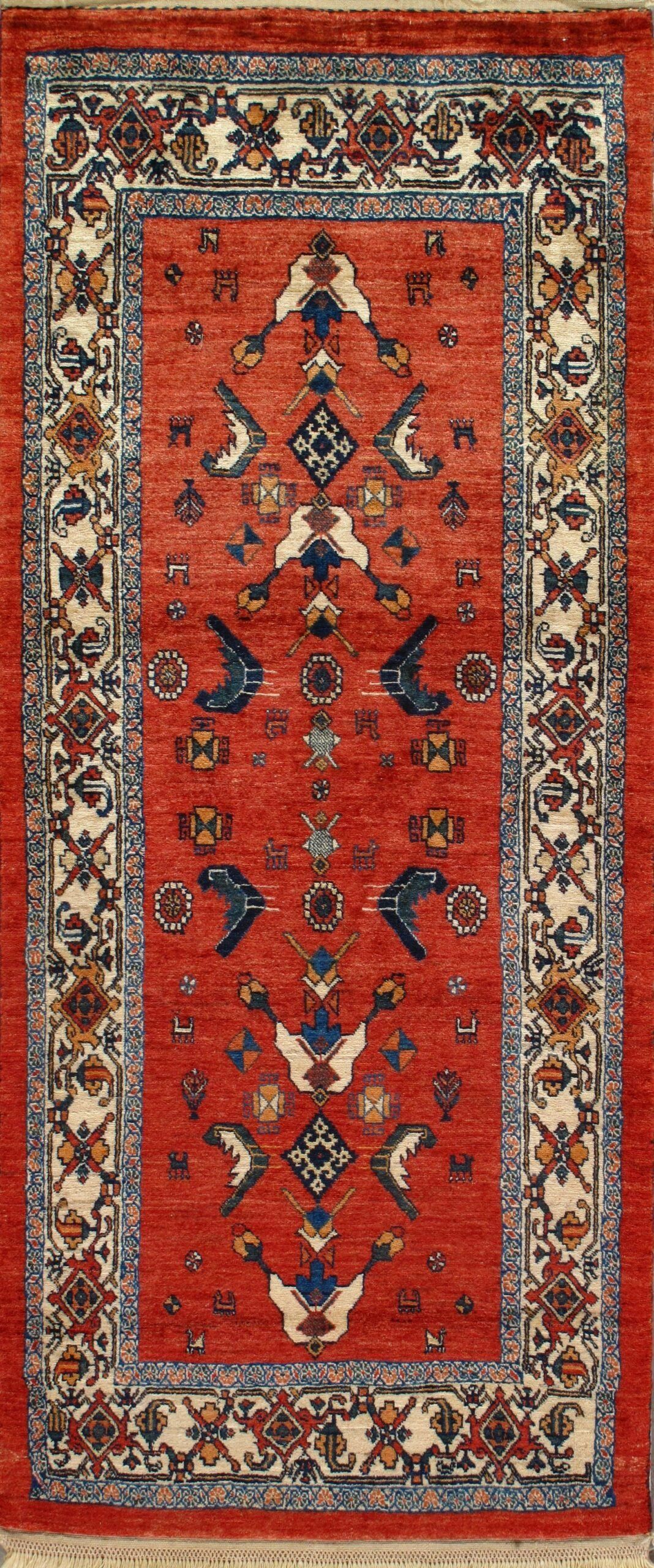 A red rug with a blue border and birds on it.
