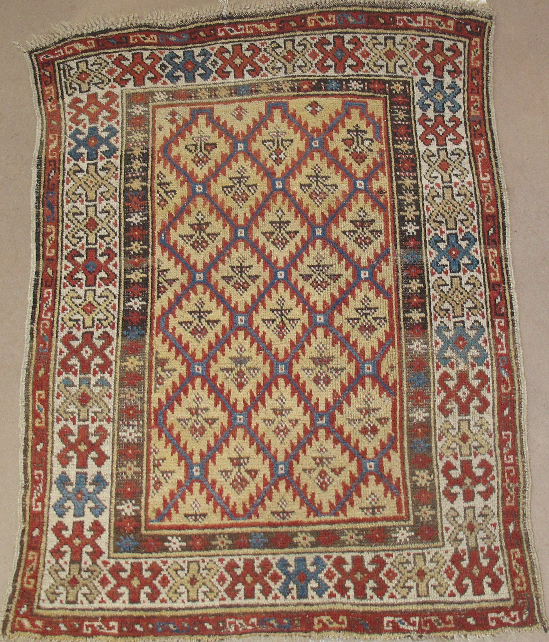 A rug with a geometric pattern is sitting on a carpet