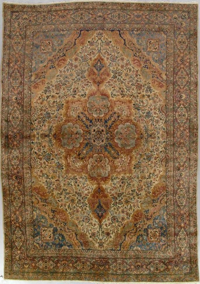 A rug with a floral pattern on it is hanging on a wall.
