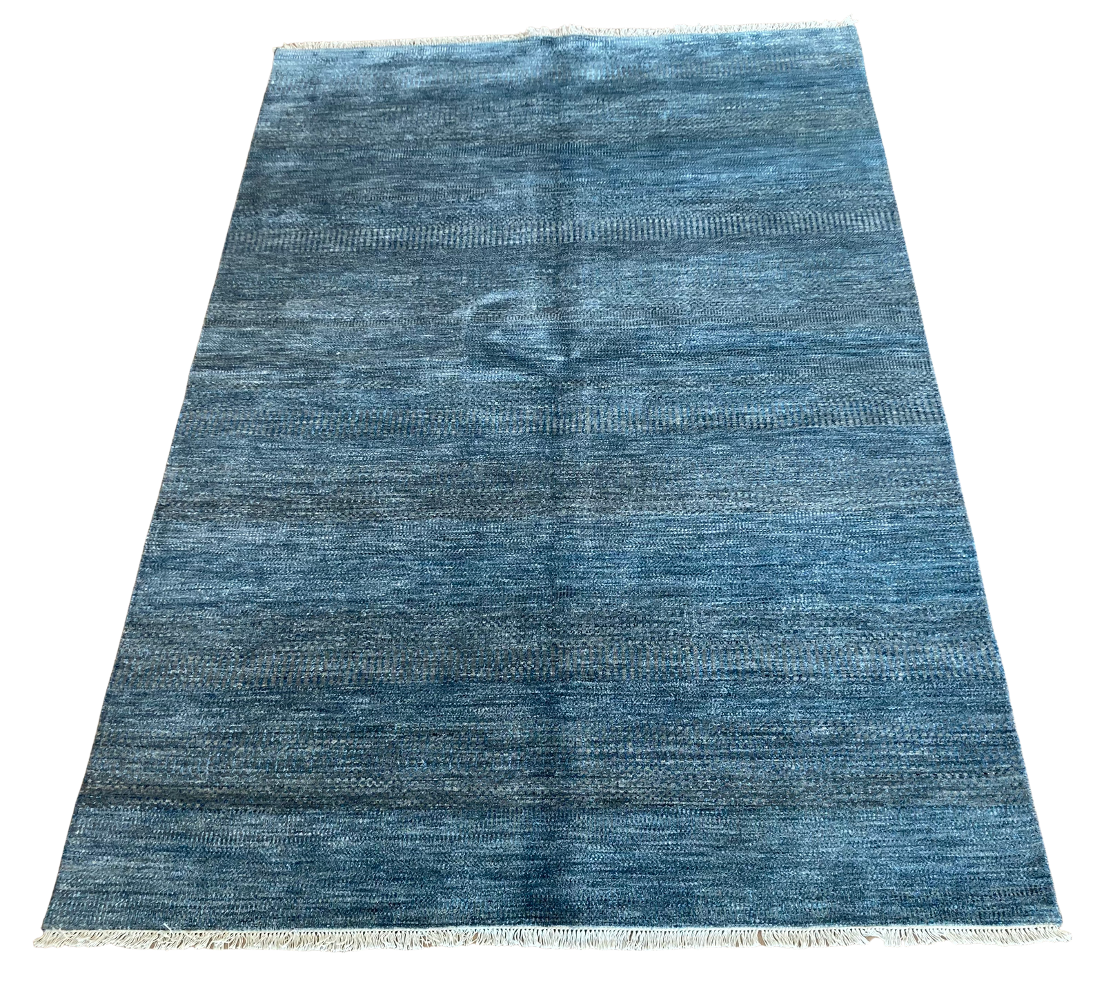 A blue rug is sitting on top of a white surface.
