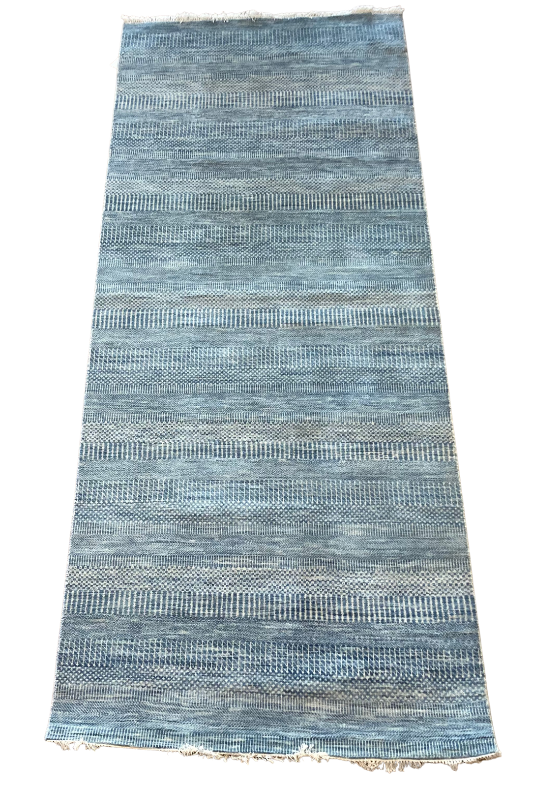 A blue rug with a pattern on it is on a white background.