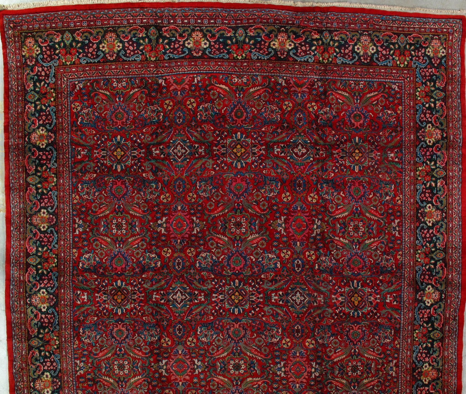 A red rug with a floral pattern and a red border