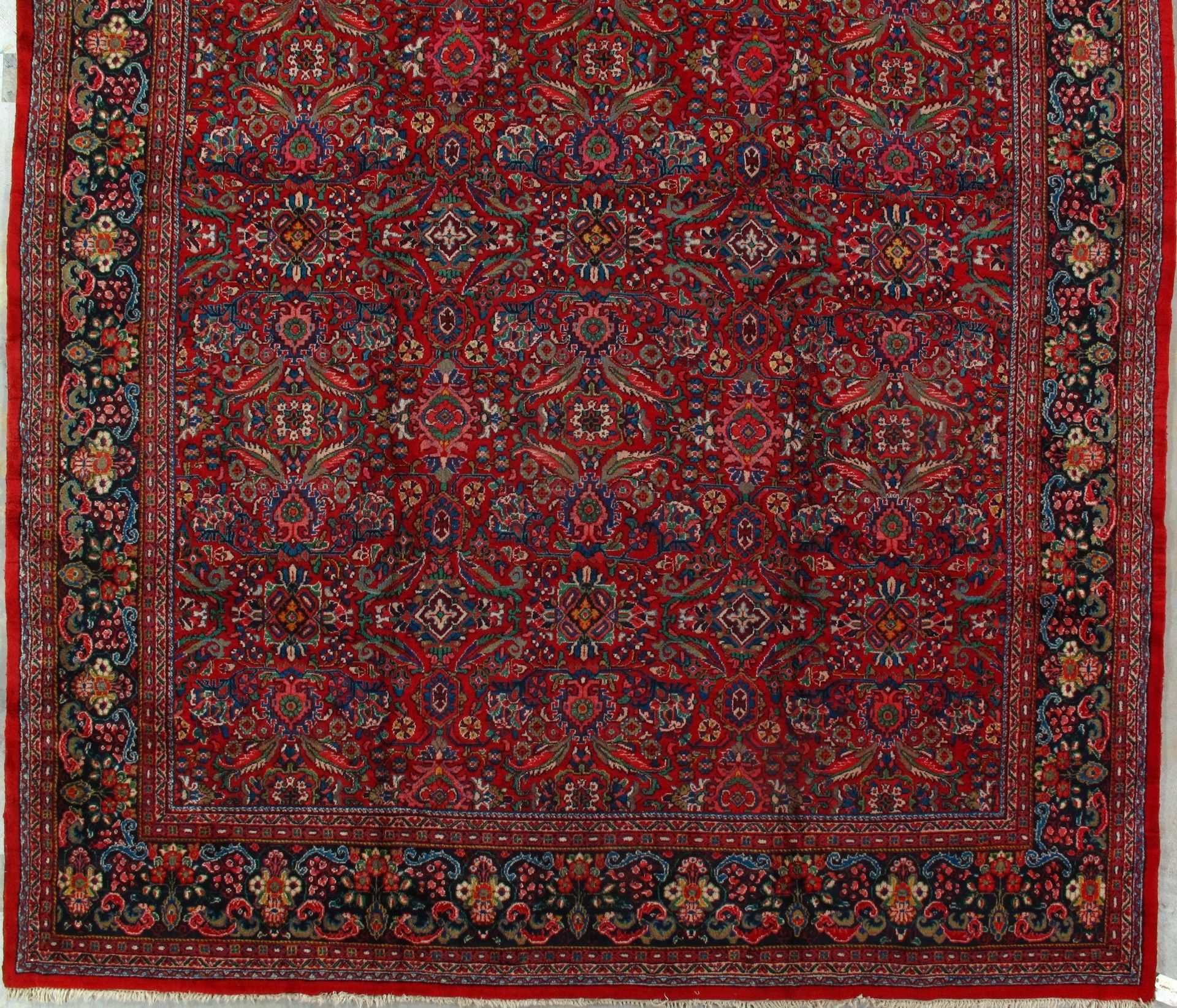 A red rug with a floral pattern and a red border