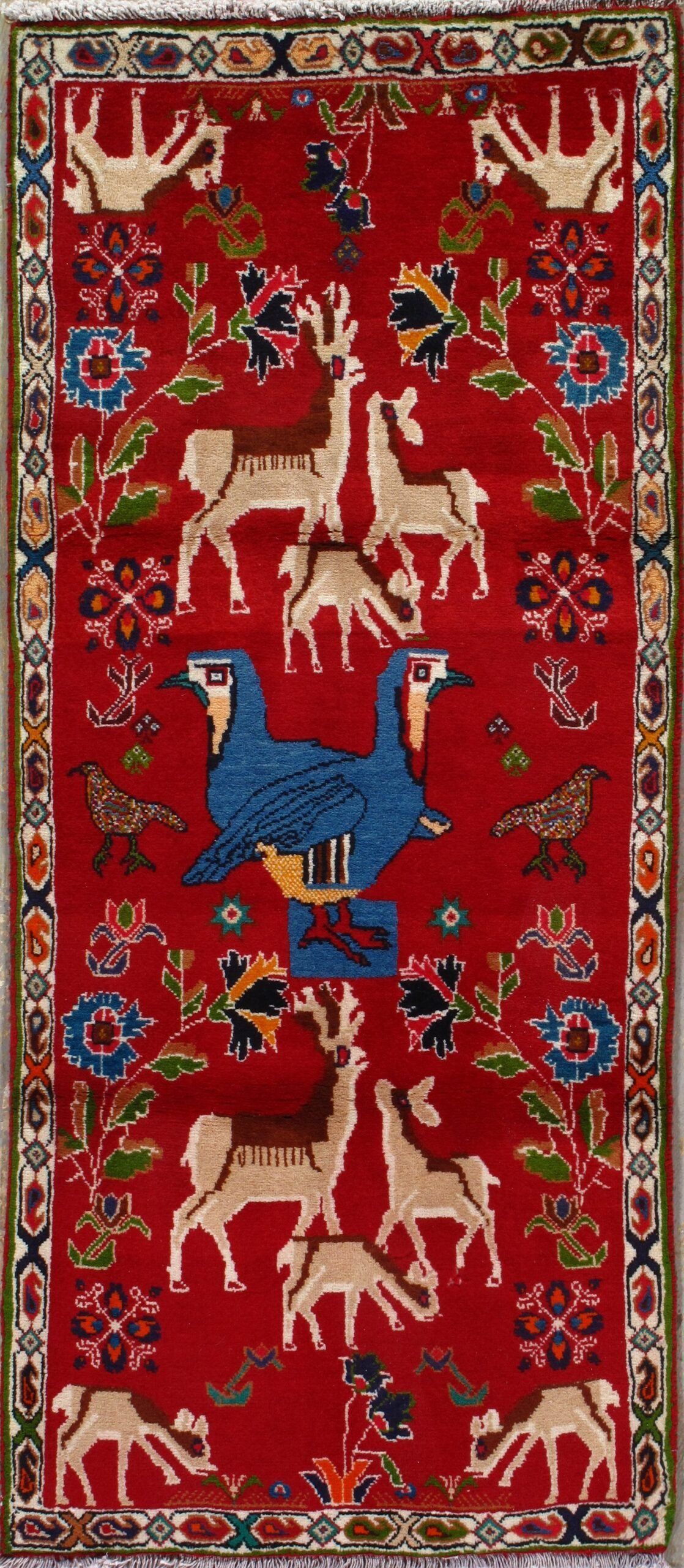 A red rug with animals and birds on it