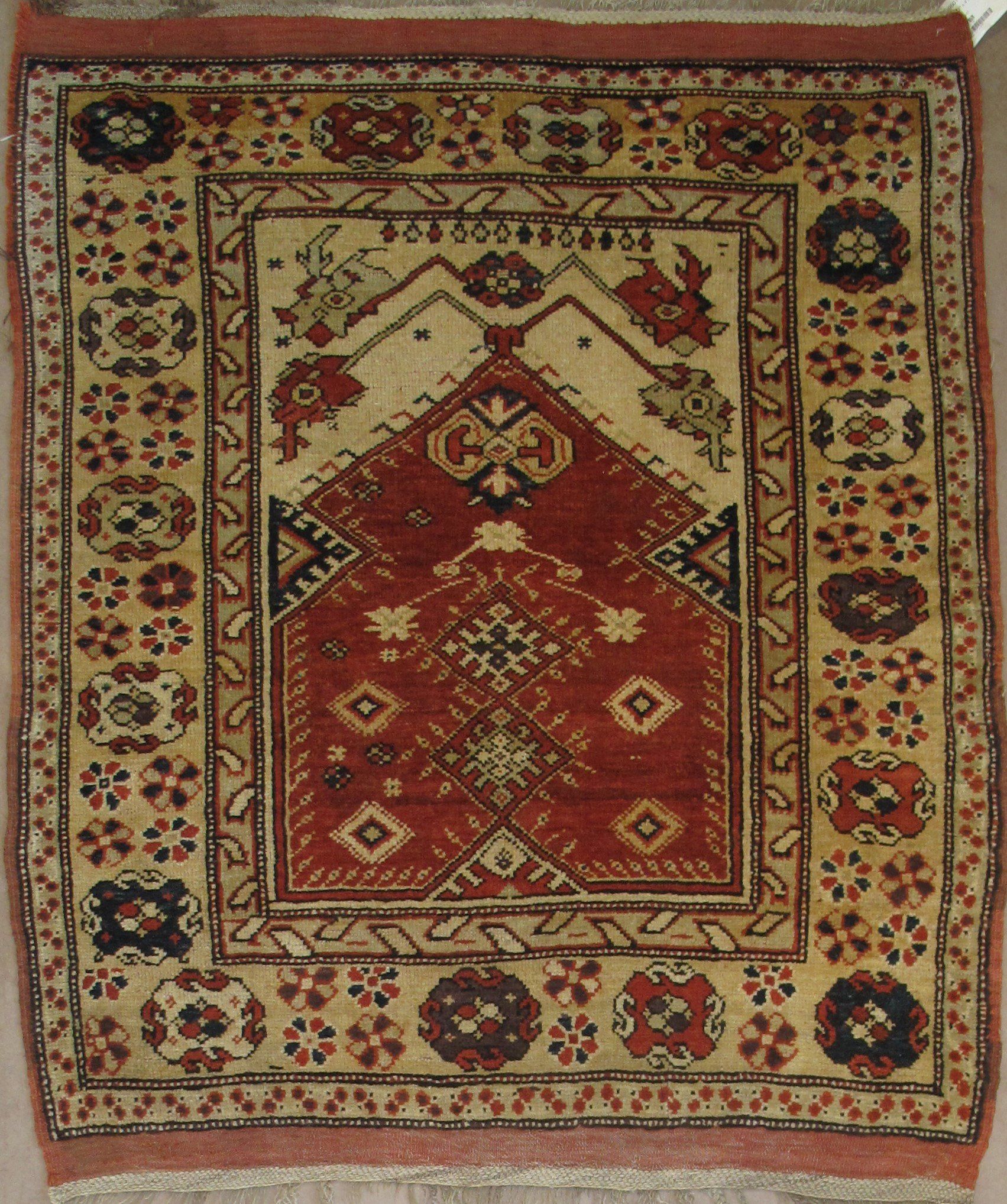 A rug with a floral pattern and a red border