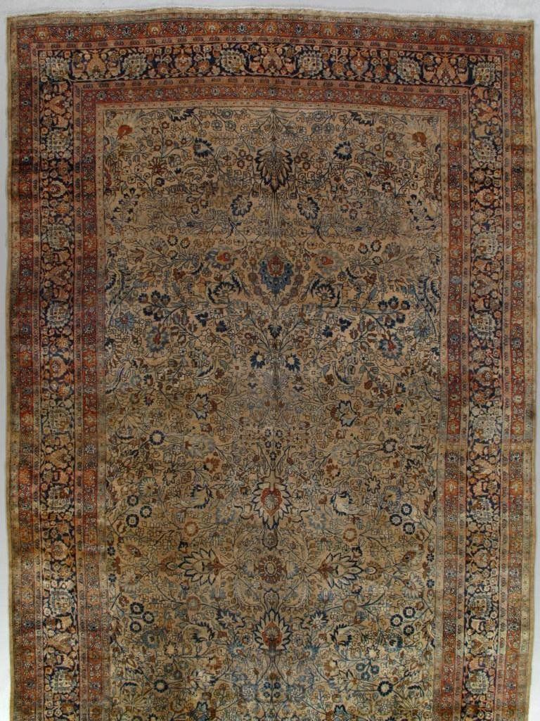 A rug with a floral pattern on it is hanging on a wall.