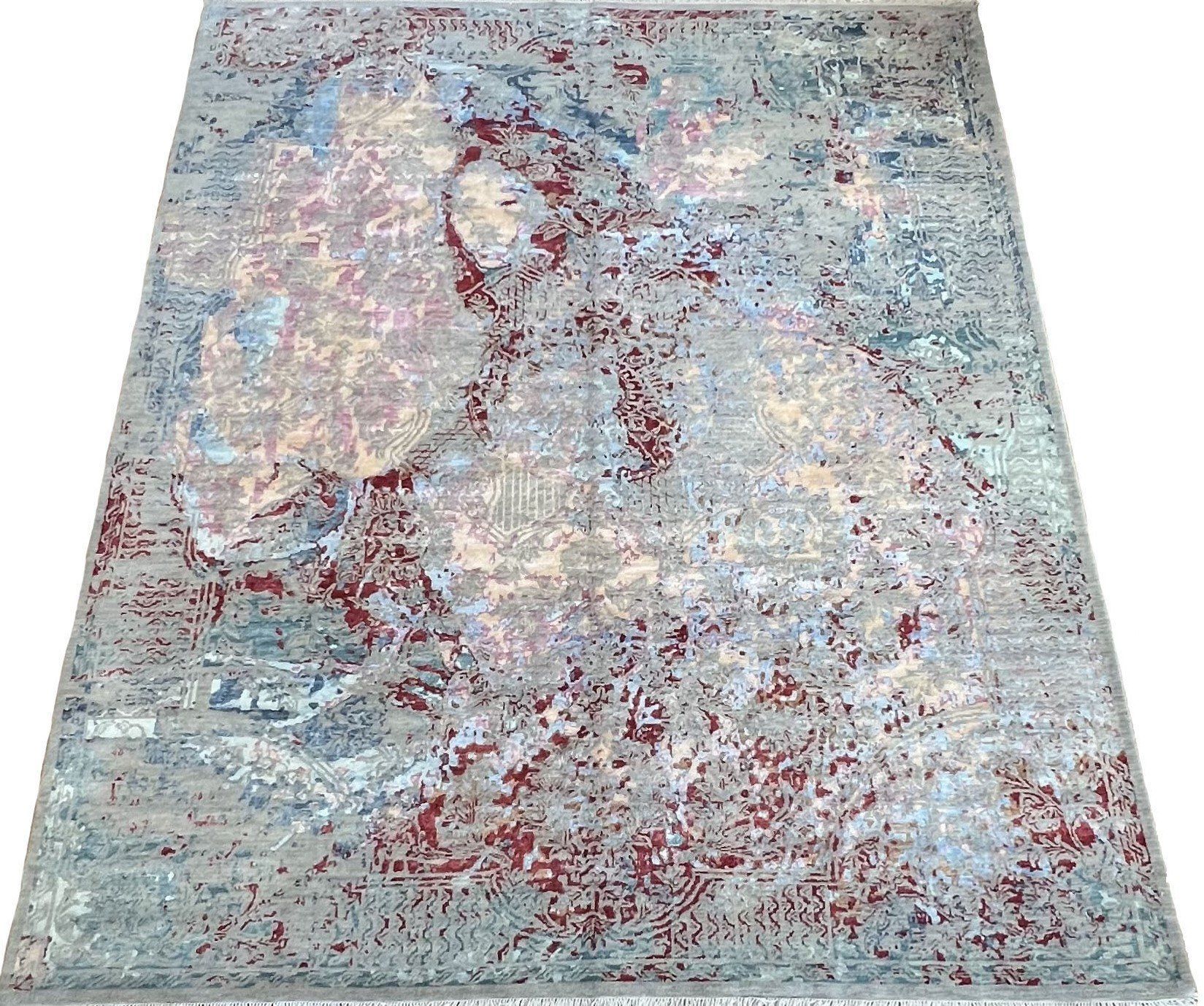 A rug with a painting on it is sitting on a white surface.