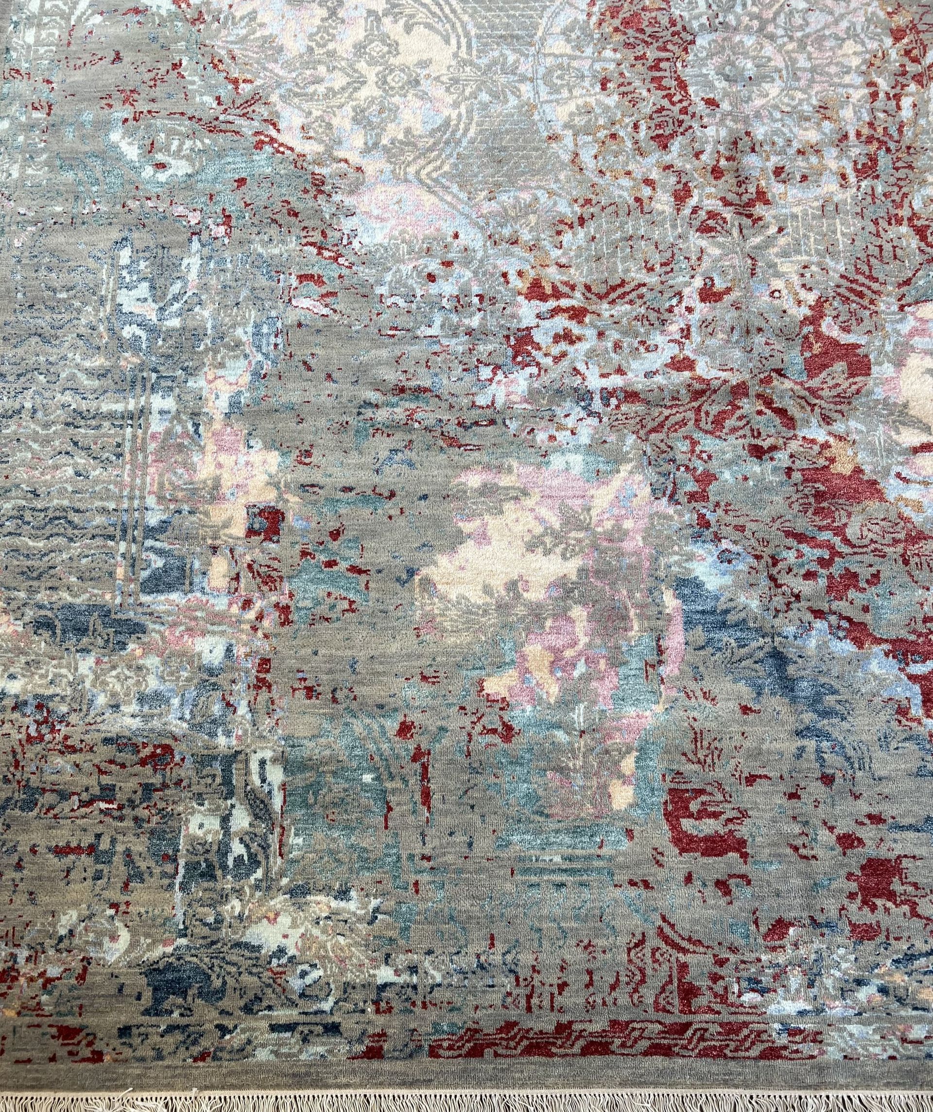 A rug with a painting on it is sitting on a white surface.