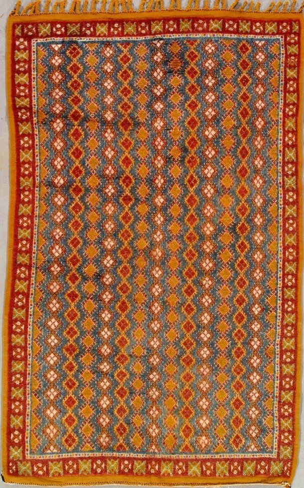 A rug with a pattern on it is hanging on a wall.