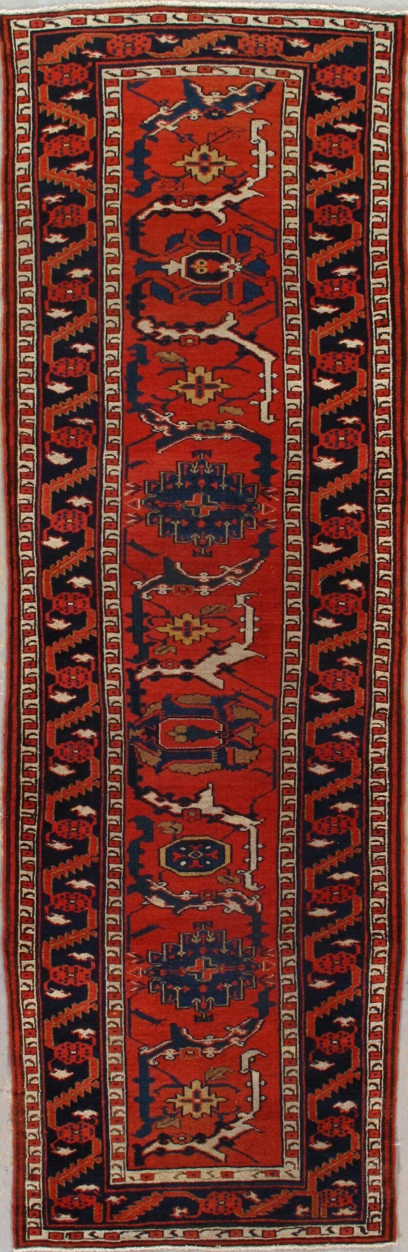 A red rug with a blue and white pattern on it