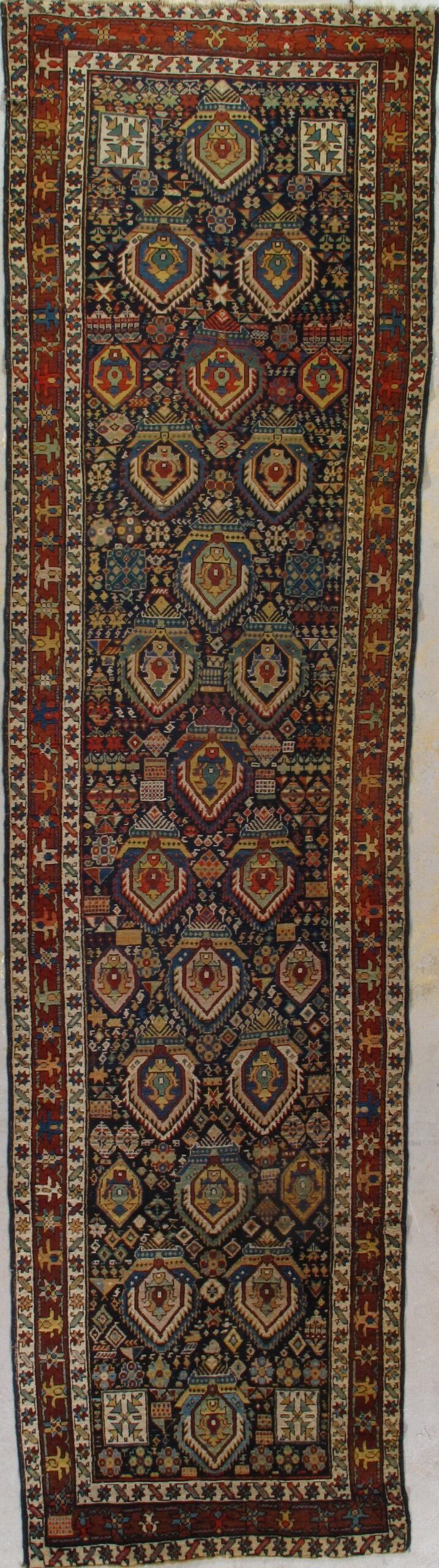 A rug with a pattern on it is hanging on a wall.