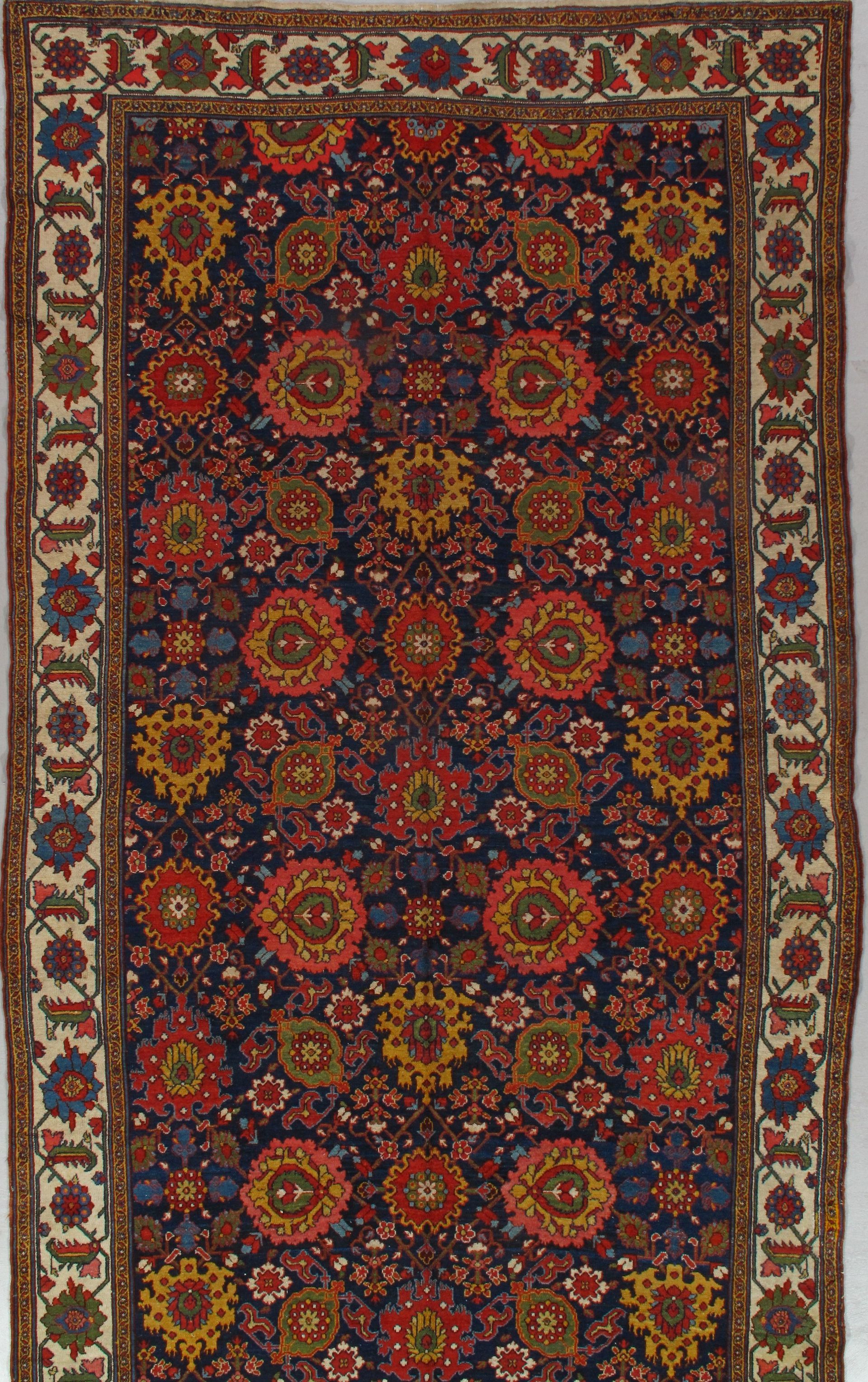 A rug with a floral pattern on it is hanging on a wall.