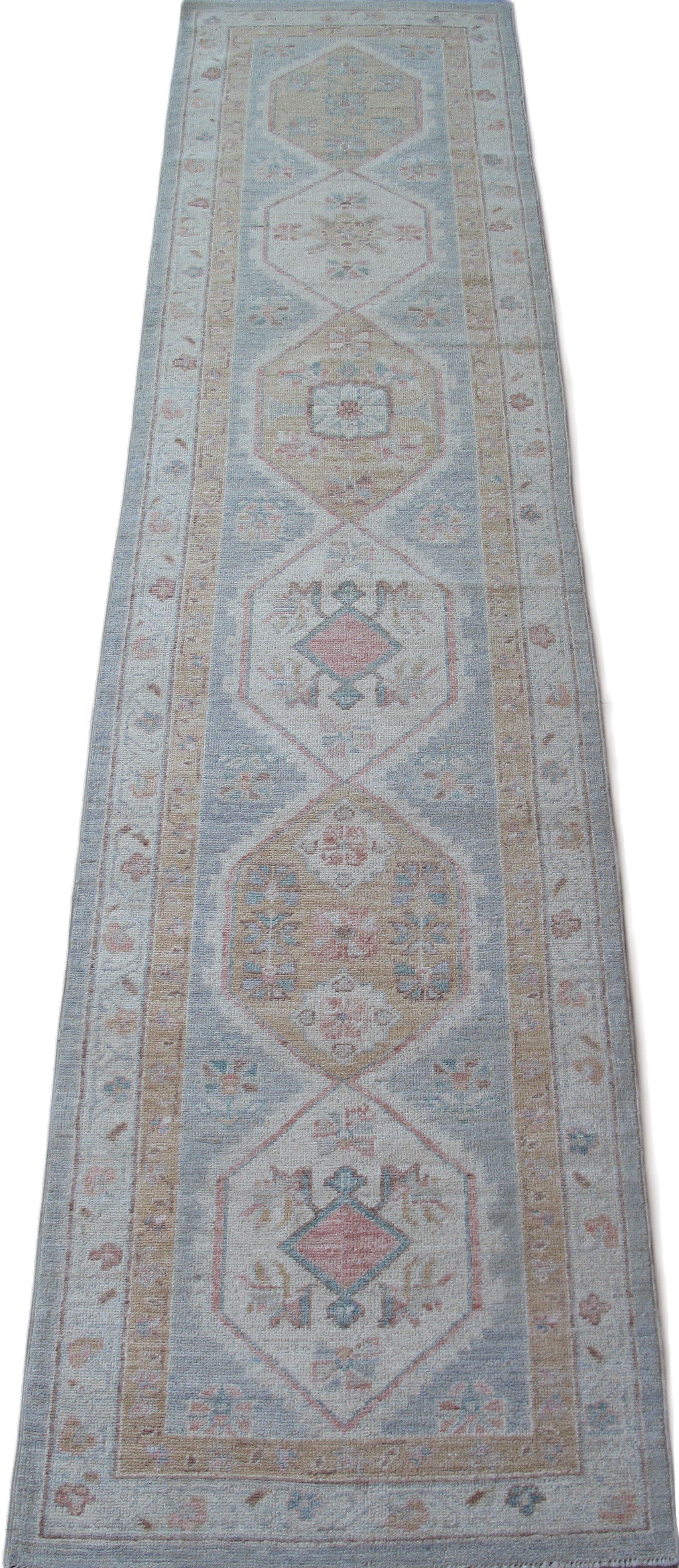 A long rug with a pattern on it is on a white background.