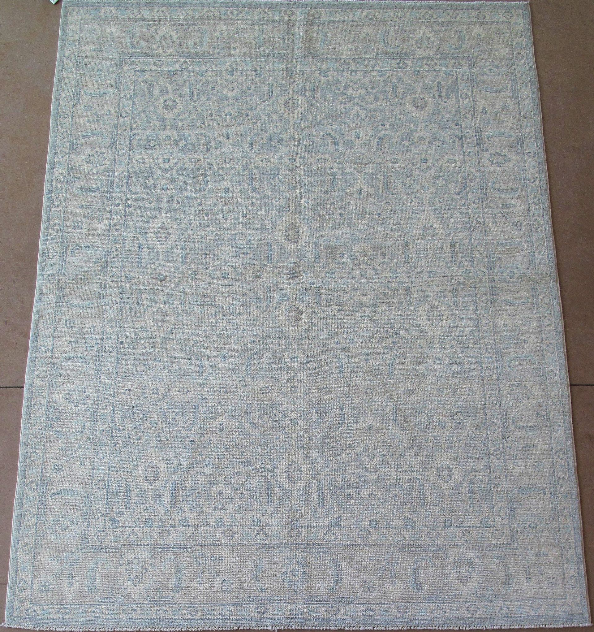 A gray rug is sitting on a brown carpet