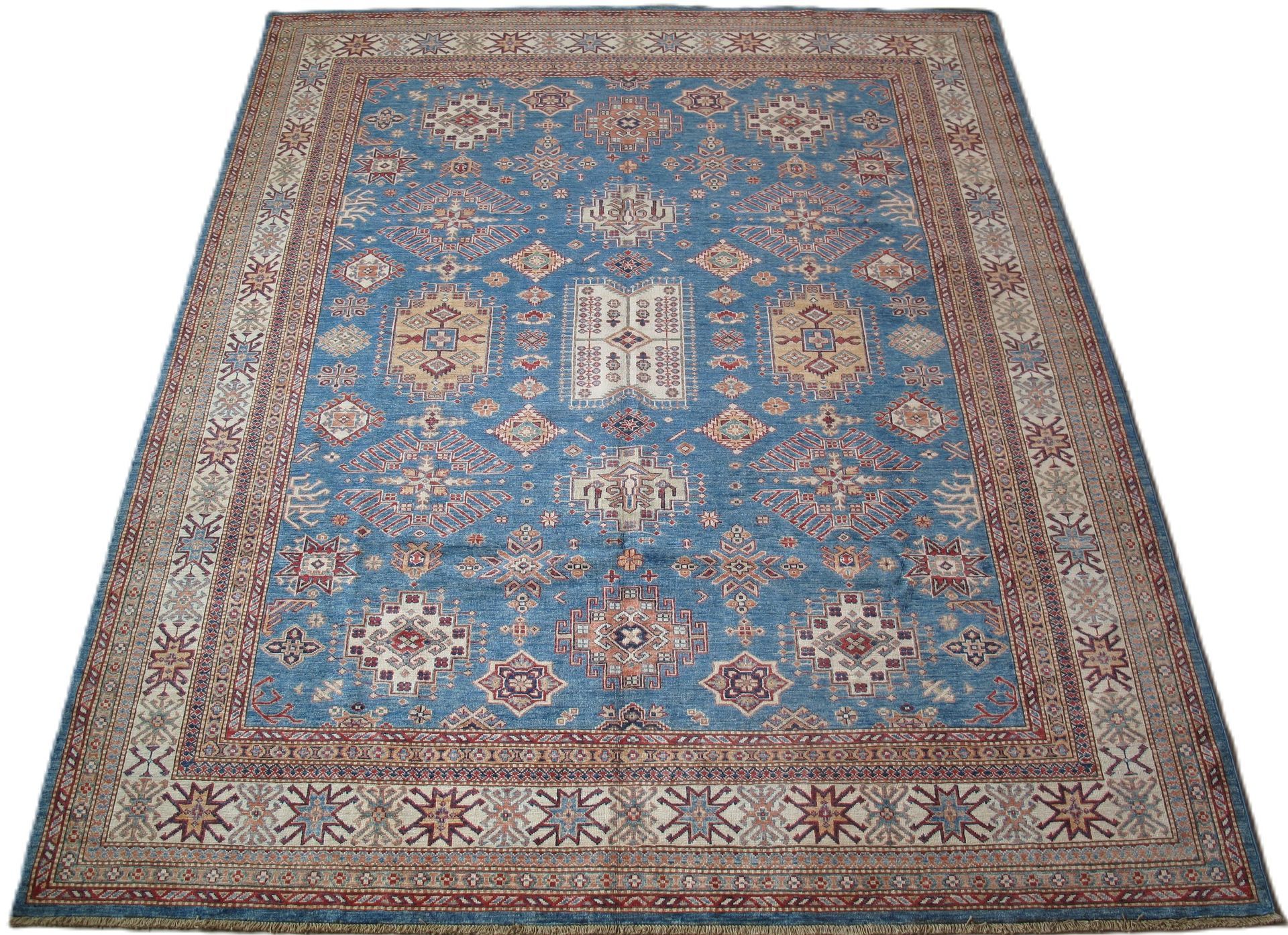 A blue rug with a pattern on it is on a white background.