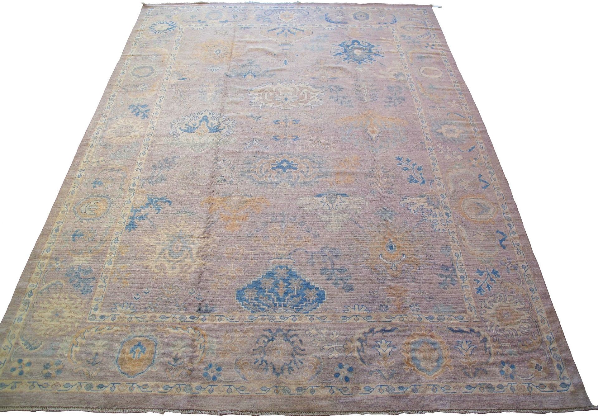 A large rug with a floral pattern is sitting on a white surface.