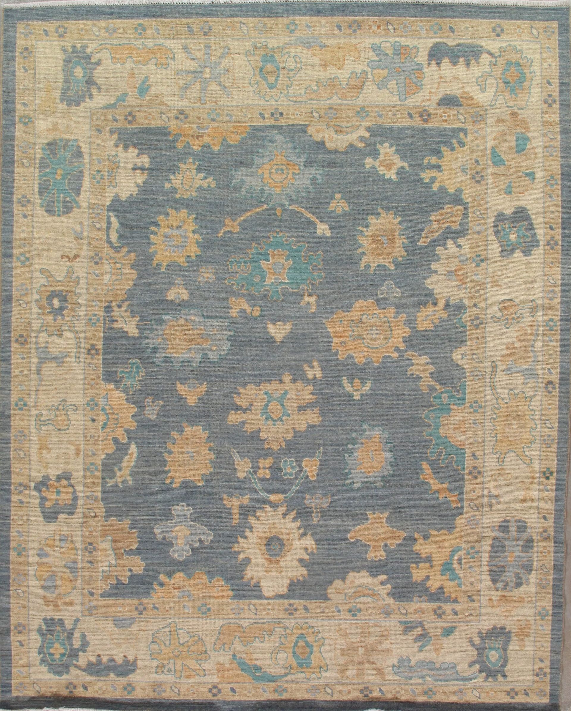 A blue and tan rug with a floral pattern on it