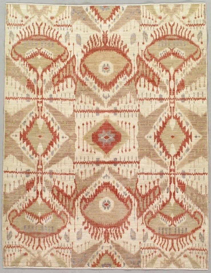 A rug with a geometric pattern on it is hanging on a wall.