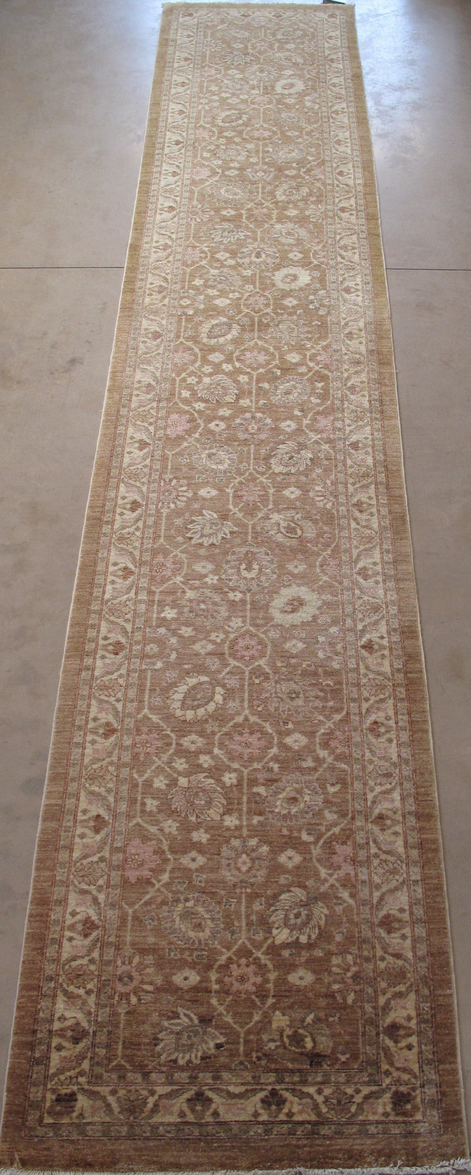 A long brown rug with a floral pattern on a white background.