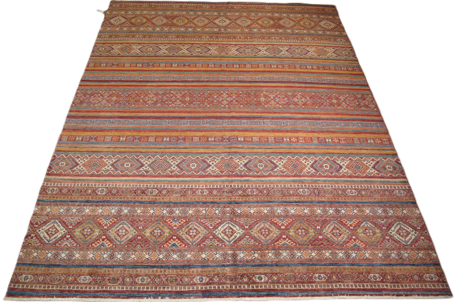 A rug with a geometric pattern on it is sitting on a white surface.