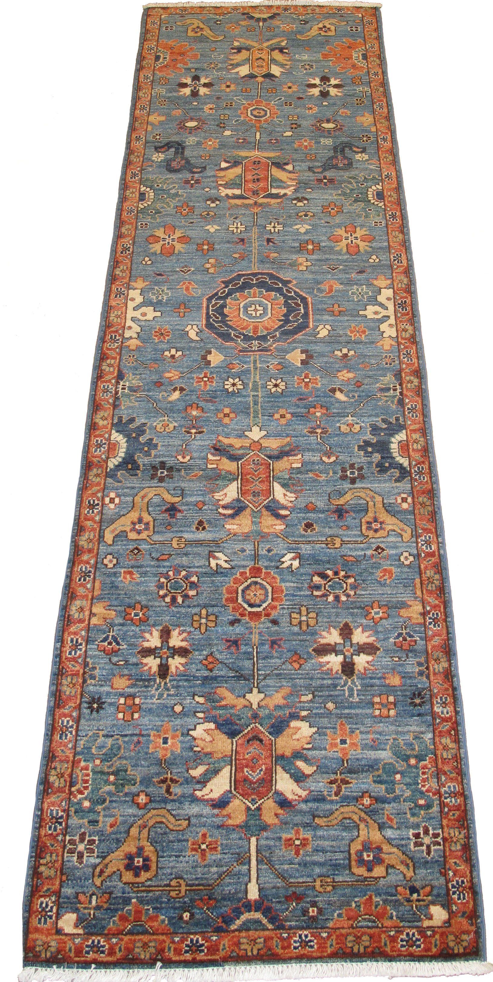 A long blue and orange rug with a floral pattern on a white background.
