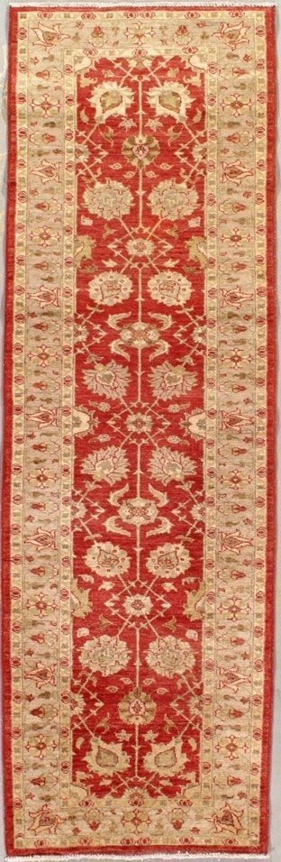 A red and beige rug with a pattern on it is sitting on a table.