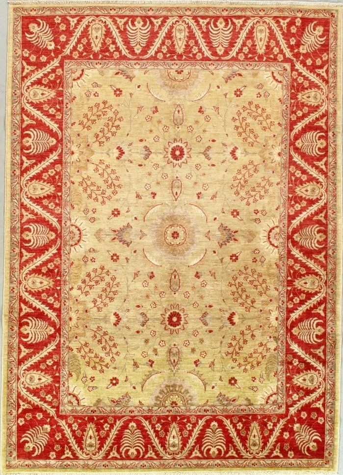 A rug with a red border is on a white surface.