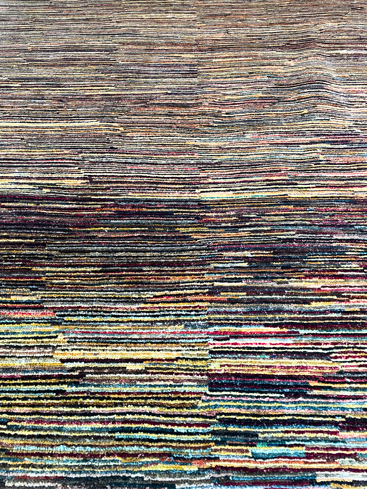 A close up of a colorful rug with a striped pattern.
