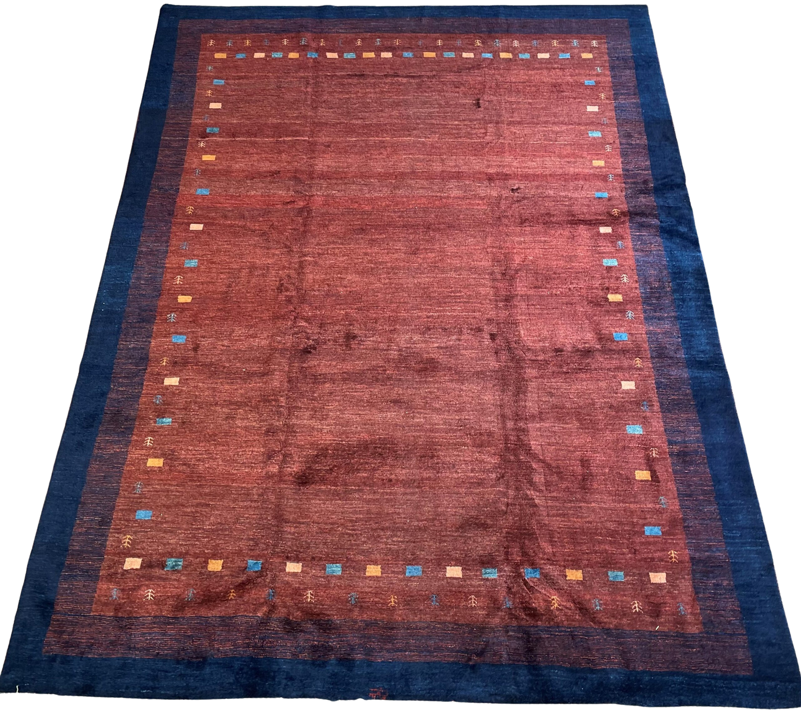 A red rug with a blue border on a white background