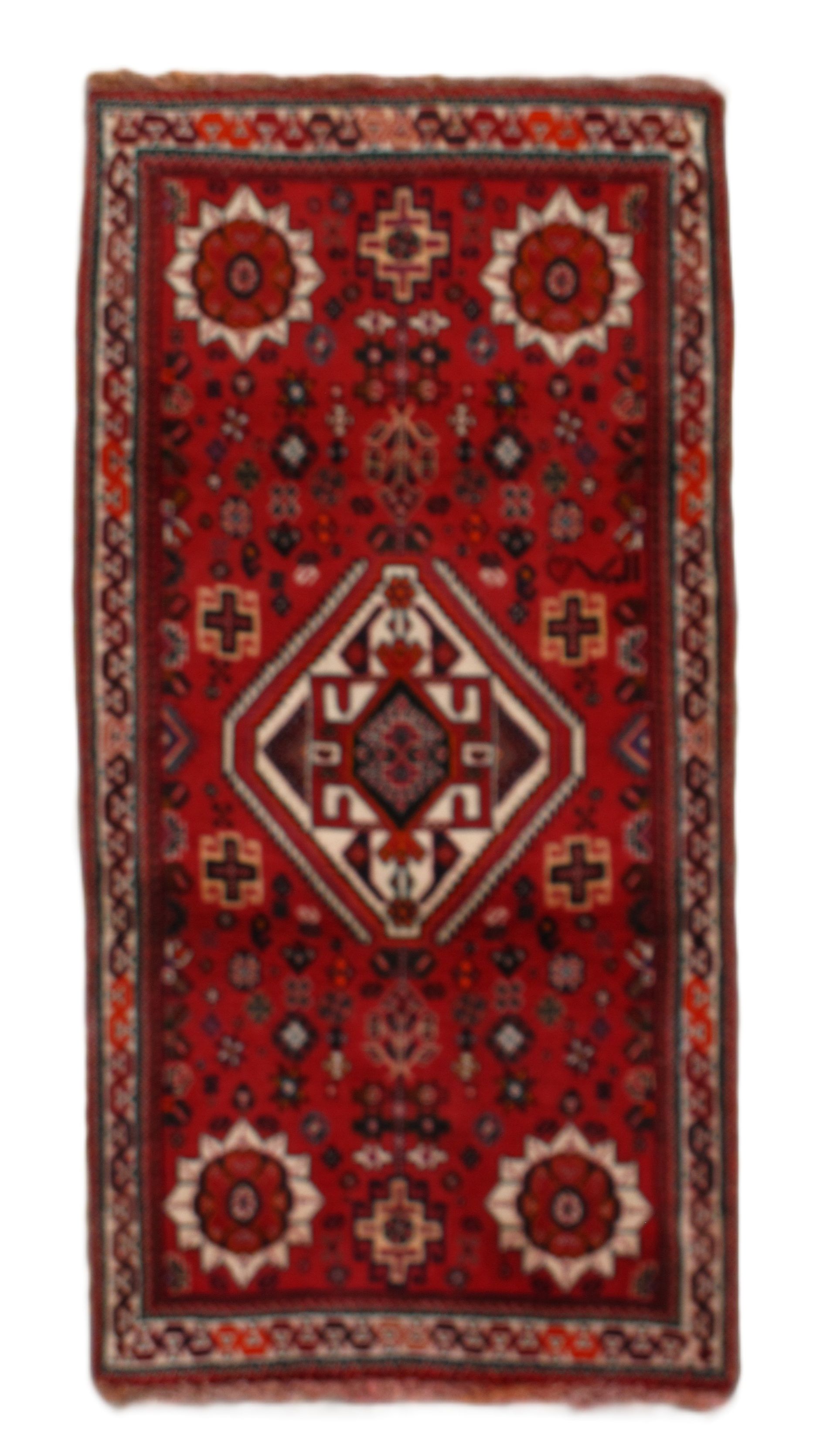 Red rectangular rug with geometric designs in white, brown, and orange.