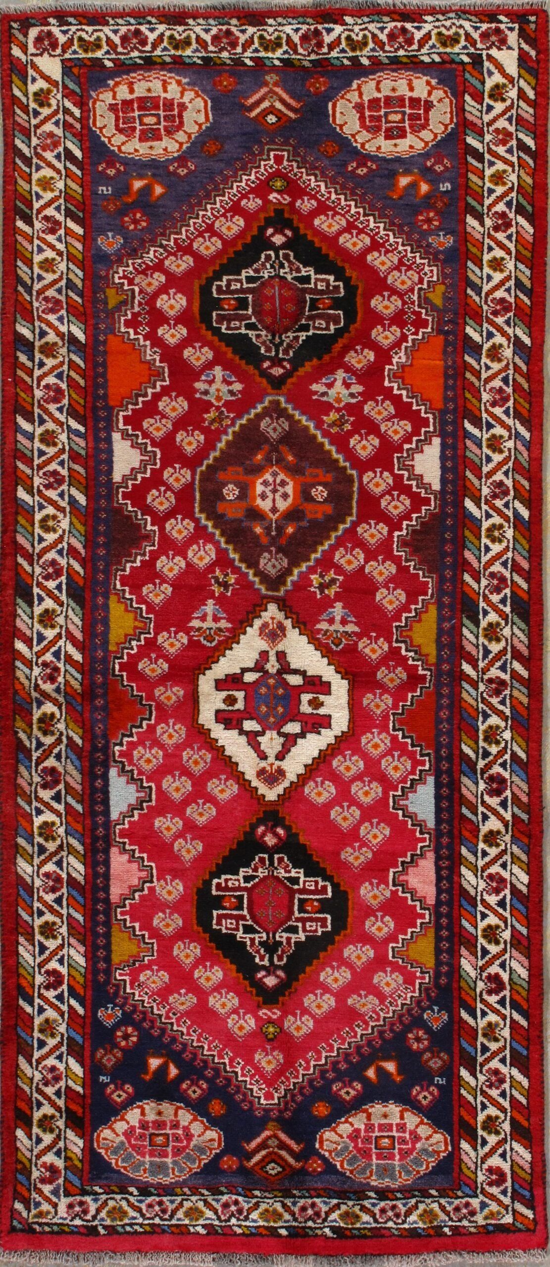 A red rug with a blue border and a pattern on it