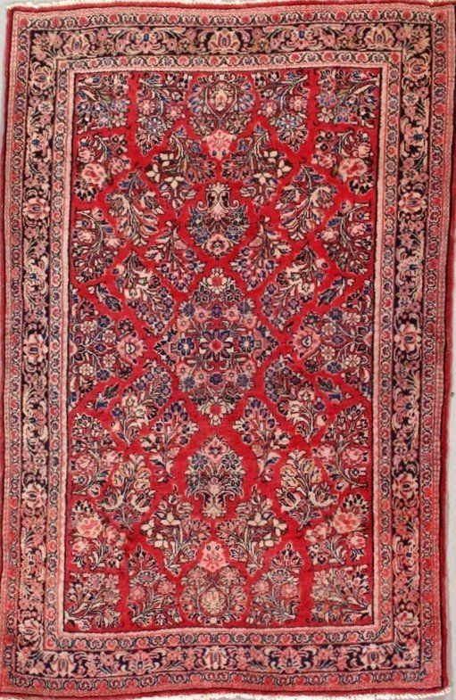 A red rug with a floral pattern on it is sitting on a table.