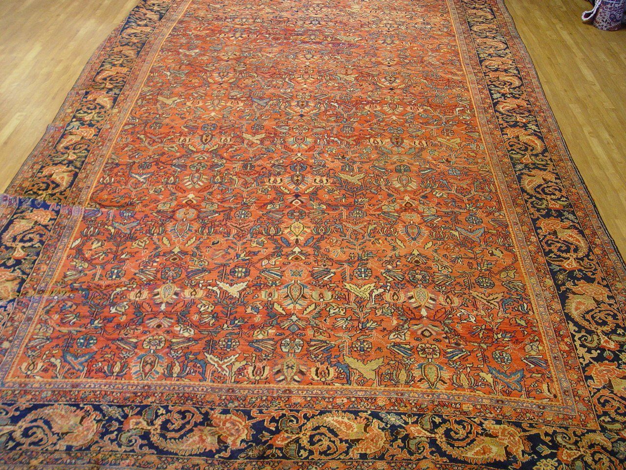 A large rug is sitting on a wooden floor