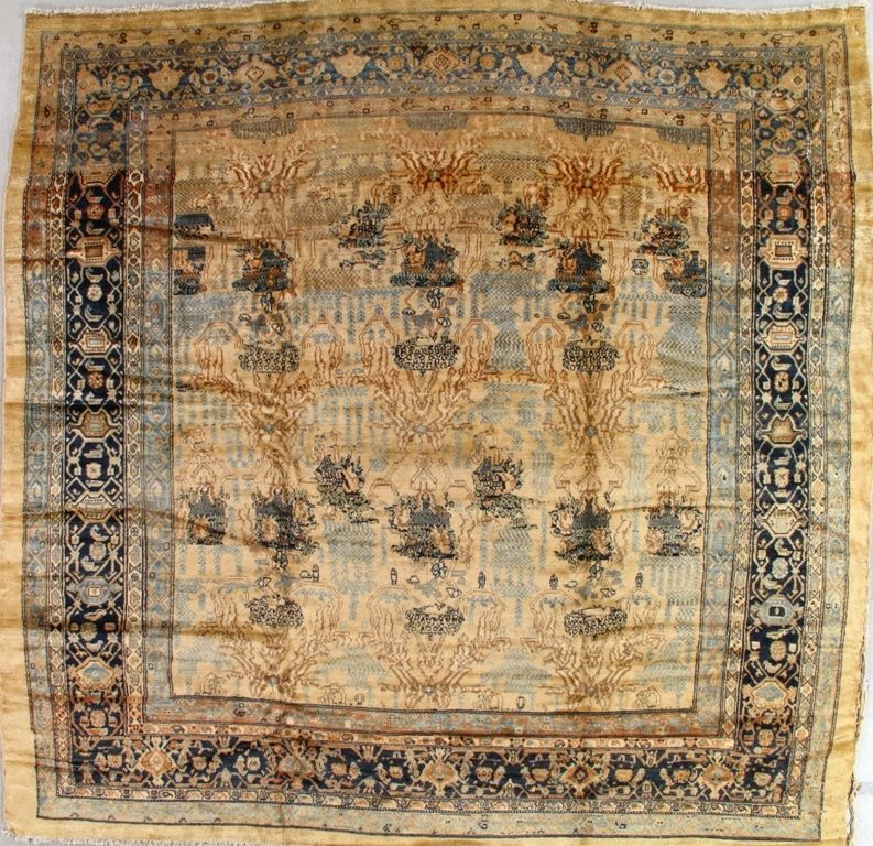 Antique rug with blue, tan, and brown geometric patterns. Border design with floral motifs.