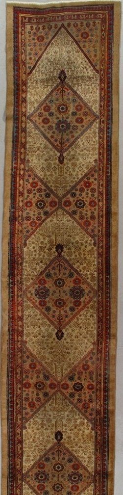 A long rug with a pattern on it is hanging on a wall.