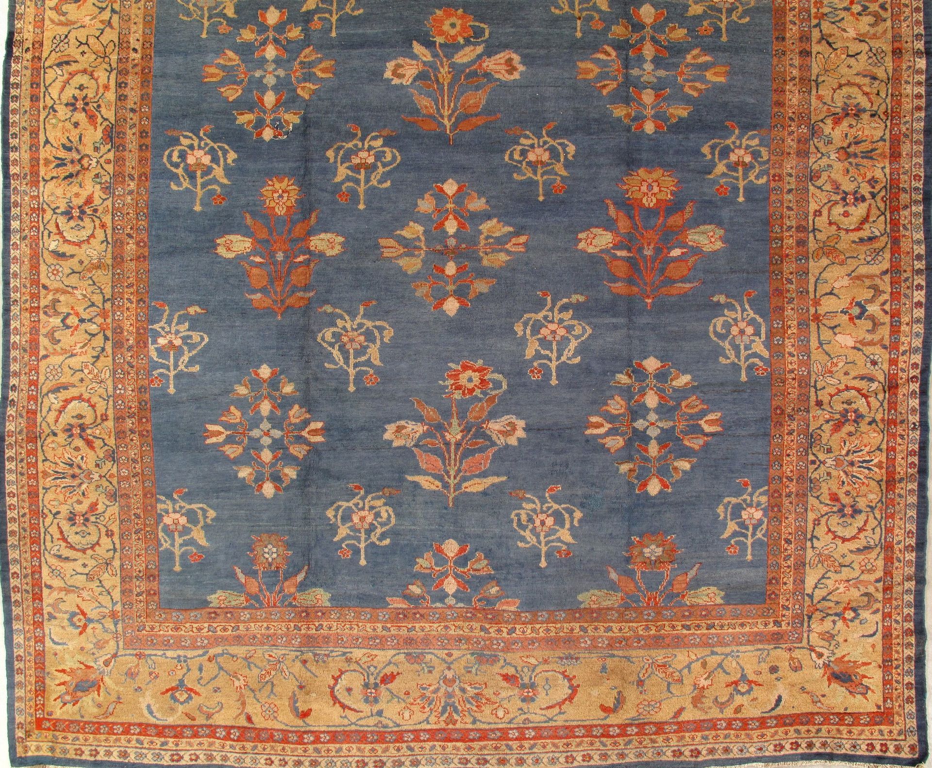 A blue and gold rug with flowers on it