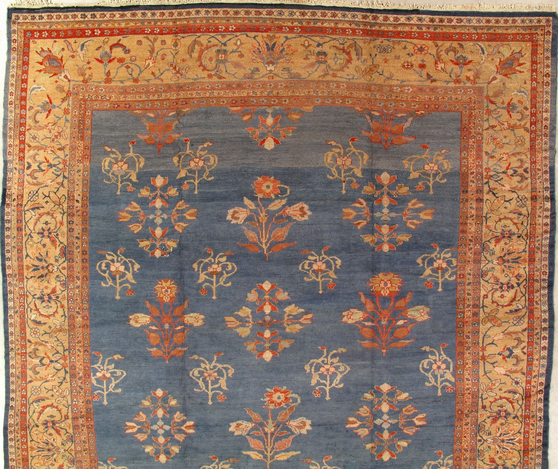 A blue and gold rug with flowers on it