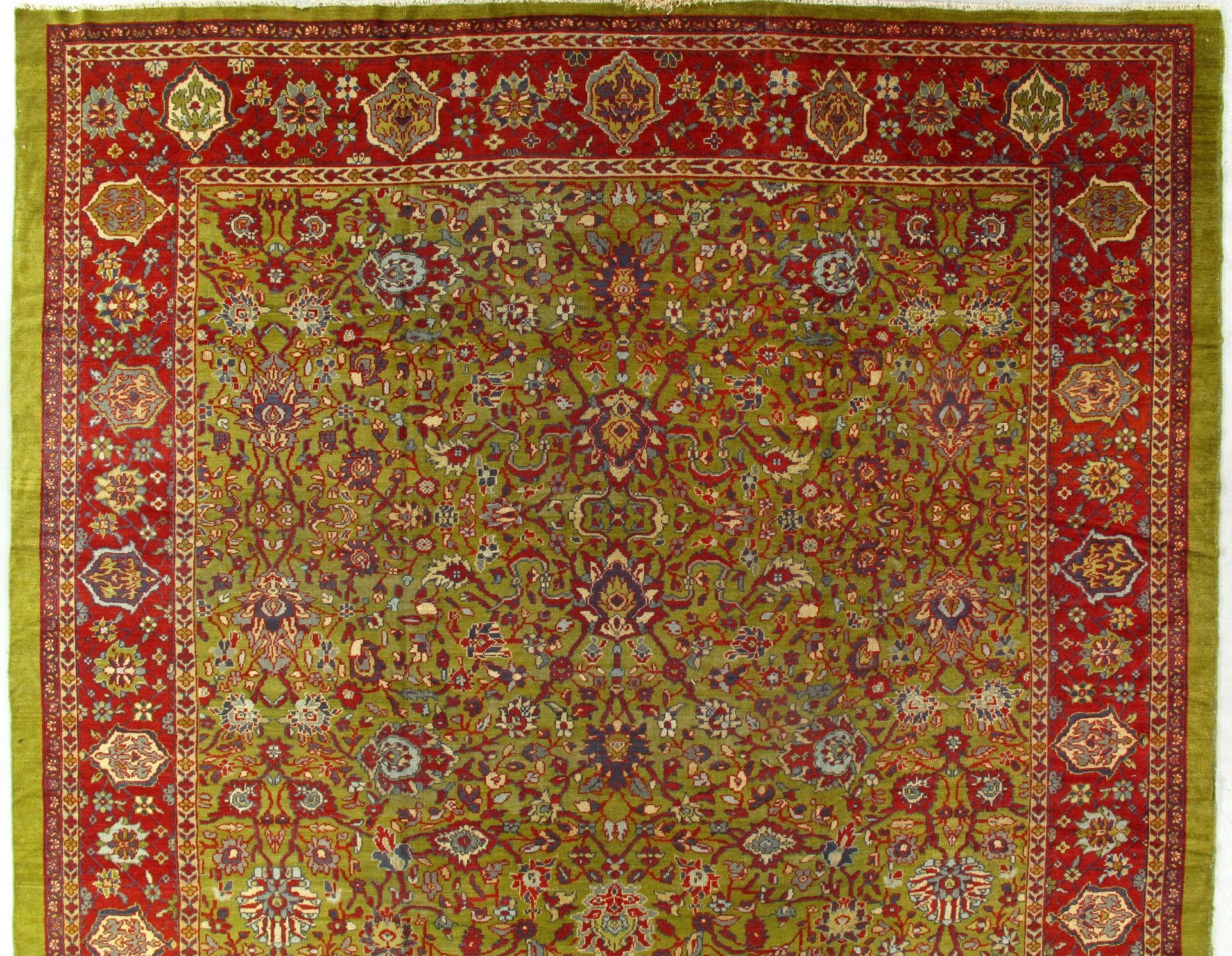A red and green rug with a floral pattern on it