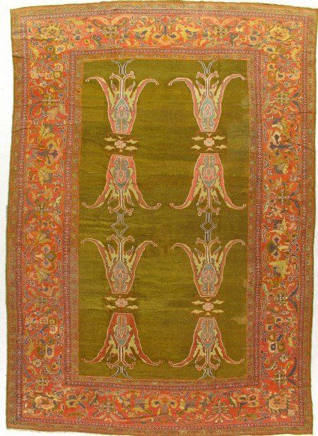 A green rug with a red border and flowers on it.
