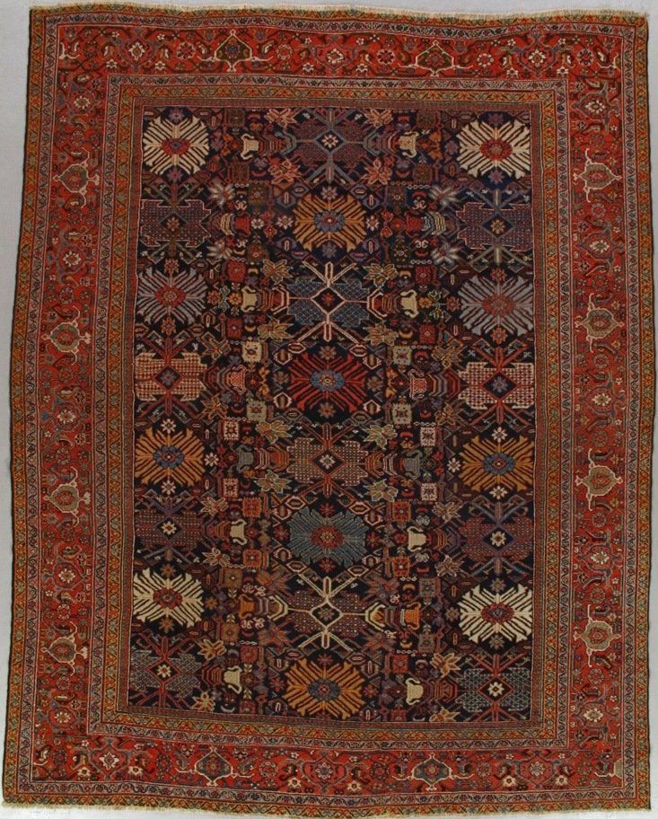 A rug with a floral pattern on it is hanging on a wall.