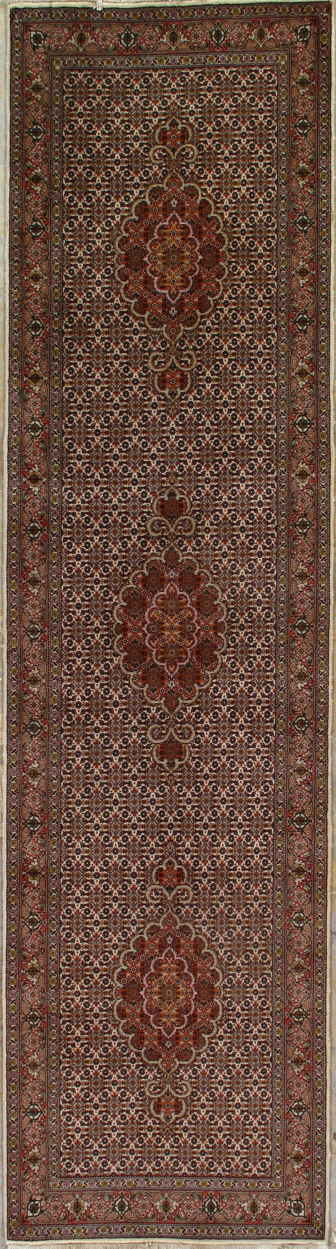 A brown rug with a pattern on it is hanging on a wall.